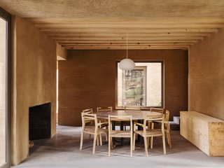 A minimalist dining table and large fireplace