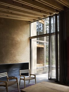 Full-height glass doors connects the living areas with the garden and forest outdoors.
