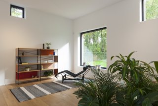 A black LC4 chaise lounge from Cassina is paired with an Eames storage shelf from Herman Miller.