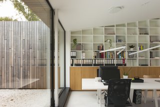 The study area has built-in shelves and a Joyn Conference Bench by Vitra.