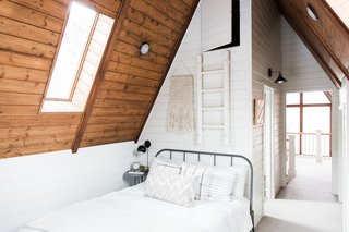 Plaid pillows and a weave on the wall bring a folksy feel to the bedroom.