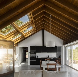 A Bright Red Island Residence Embraces a Linden Tree - Photo 5 of 13 - The dining and kitchen areas