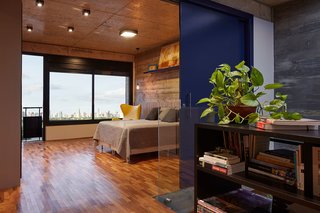 This Slender Concrete Home in Brazil Feels Like an Urban Jungle - Photo 9 of 13 - The master bedroom looks out to city views.