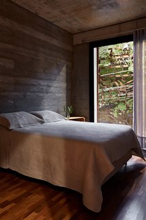 This Slender Concrete Home in Brazil Feels Like an Urban Jungle - Photo 10 of 13 - The Cor-Ten steel enclosure provides more privacy for the bedrooms while serving as a striking, decorative façade.