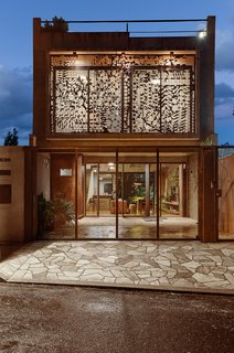 This Slender Concrete Home in Brazil Feels Like an Urban Jungle - Photo 4 of 13 - A Cor-Ten steel sculpture designed by the plastic artist Nivaldo Tonon acts as a window screen.