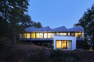 A sheltered walkway provides shade in summer, and admits the lower winter sun indoors to warm up the dark, glossy concrete floors.