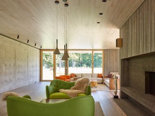 Above is a green Finnjuhl sofa and table at the fireplace, as well as pendants from Foscarini.