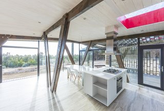 The light wood floors and glossy white kitchen give the interior a bright and minimalist feel.