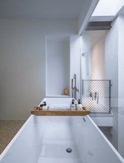 A 19th-Century Dutch Workshop Is Now a Stunning, Spacious Loft - Photo 9 of 13 - The bathtub rests along a fully glazed wall, and looks down to the living area below.