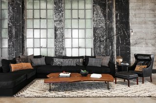 A custom-made coffee table by Alexander Design and Spark and dowel sits in the living room. The sofa and cushions are also by Alexander Design, and the armchair is from Illum Wikkelsø.