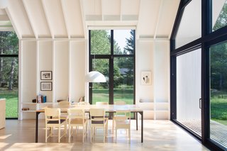 Three tall glass panels are fitted along both sides of the house, making the inside space feel similar to a light-filled pavilion.