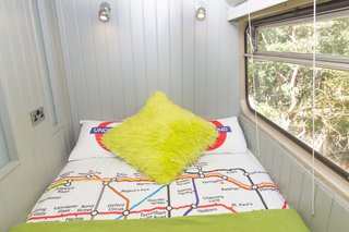 A small bedroom that looks out to the forest.