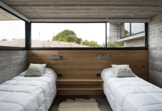 This Stacked Concrete Home Is Not Your Typical Golf Course Dwelling - Photo 5 of 17 - A guest bedroom that's located on the lowest volume is partially submerged in the dunes.