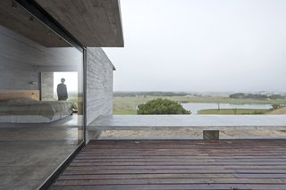 This Stacked Concrete Home Is Not Your Typical Golf Course Dwelling - Photo 10 of 17 - From the master bedroom, the owners can look out to a lake that's part of the golf course.