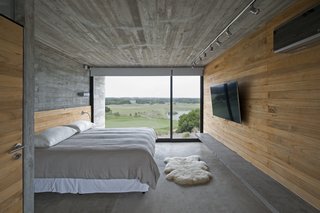 This Stacked Concrete Home Is Not Your Typical Golf Course Dwelling - Photo 11 of 17 - Kiri wood walls help keep the bedroom cool during the warm months.