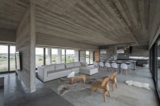 This Stacked Concrete Home Is Not Your Typical Golf Course Dwelling - Photo 7 of 17 - The raw concrete is complemented beautifully by warm wood details, as well as cream colored furniture.