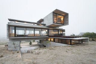 This Stacked Concrete Home Is Not Your Typical Golf Course Dwelling - Photo 2 of 17 - The cavern-like space underneath the middle volume serves as a parking area.