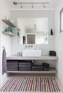 Built-in shelves and an unframed mirror give the bathroom vanity a clean and streamlined look.