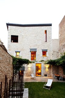 A wisteria-shaded courtyard and garden with a dining area.