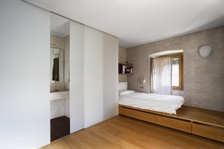 A warm and simple bedroom with an ensuite bathroom.