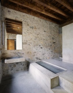 A clean-lined bathroom of stone and concrete.