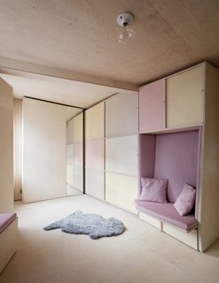 The fully-concealed workstation and storage next to a cozy bench seat.