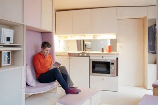 10 Things You Should Know Before Moving Into a Tiny Home - Photo 11 of 20 - Jack Mama enjoys a book on the lounge seat with a pullout ottoman.