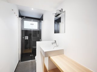 Before and After: A Renovated Artist's Studio Is Now an Airy, Efficient Home - Photo 14 of 16 - The bathroom has an elevated shower area with frosted glass windows that look out to a quiet alley.