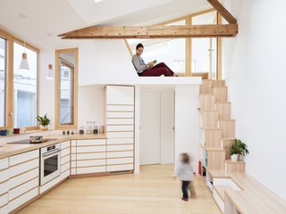 In Paris, a painter's granddaughter turns a 484-square-foot studio into a minimalist family home that abounds with smart storage and integrated furniture. A reading nook in front of the "cabin" workspace is at the top of the stairs.