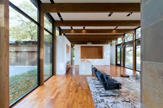 The glossy white kitchen gives the open-plan living space a clean and modern look.