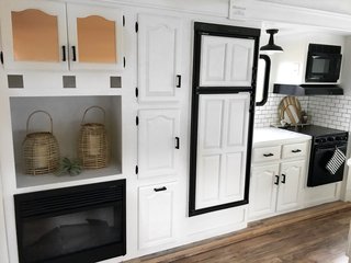 The kitchen has a fireplace, oven, microwave, electric cooktop, and plenty of discreet storage.
