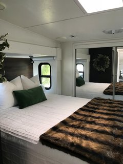 A skylight window illuminates the bedroom, which appears larger than it is because of the closet with mirror-clad sliding doors.