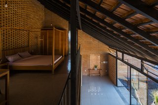 Light and Shadow Help Shape This Modern Brick House in Vietnam - Photo 9 of 15 - The mezzanine bedroom looks down to a buffer space between the front yard and the living areas.