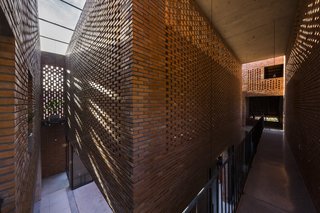 Light and Shadow Help Shape This Modern Brick House in Vietnam - Photo 11 of 15 - A corridor on the upper level connects the two roof structures.