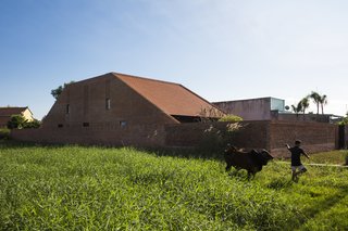 Light and Shadow Help Shape This Modern Brick House in Vietnam - Photo 1 of 15 - Designed by Tropical Space, Long An House uses strong, modern, architectural language to update the concept of the traditional Vietnamese house. From the street level, the house looks like an ordinary, pitched-roof building.