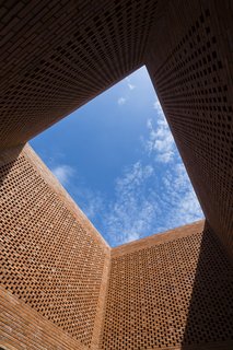 Light and Shadow Help Shape This Modern Brick House in Vietnam - Photo 5 of 15 - A large expanse of blue sky is seen from the courtyard.