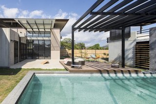 A Concrete Abode Becomes a Surfer's Paradise - Photo 6 of 23 - The layout of the three buildings creates a private garden space within the site. One building houses the bedrooms, while the other two feature several social zones.