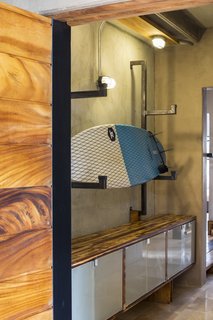 A Concrete Abode Becomes a Surfer's Paradise - Photo 3 of 23 - The team has built ample storage racks for surf boards and other outdoor equipment.