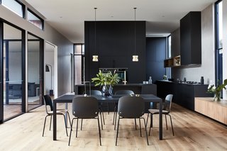 The simple and stylish dining set complements the dark kitchen.