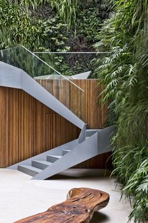 Stairs lead up from the garden to the pool and deck.