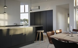 A peek at the dark, streamlined kitchen in the open-plan living area.