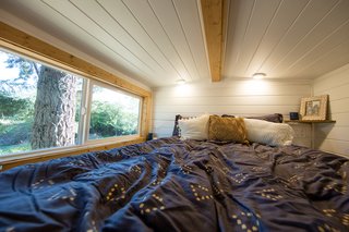 Above the bathroom is a cozy sleeping loft with a double bed. This space, along with the lofted lounge above the dining area can be accessed with a moveable ladder.
