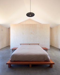 On the upper level is a corridor with a studio, library, and gallery that leads to the ensuite master bedroom.