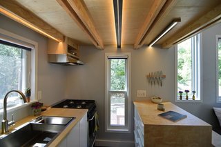 The galley-style kitchen—located below the sleeping loft— has identical operable windows on each side to bring in an abundance of light and cross breezes. 