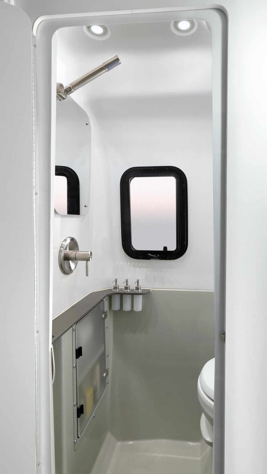 Within its sleek, modern fiberglass shell are plenty of stylishly concealed storage units, a kitchenette with a two-burner stove, sink and microwave, and a wet bath.