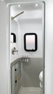 Within its sleek, modern fiberglass shell are plenty of stylishly concealed storage units, a kitchenette with a two-burner stove, a sink and microwave, as well as a wet bath. 
