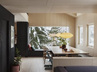 The dining area has a large table where family members can sit together but engage in different activities, exemplifying how a space can be at once communal and private.