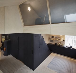 Named "House of Many Worlds," the impetus behind project was to create depth within the 1,000-square-feet space, so the architects used perforated steel plates to separate the loft area from the large living space below it. Most of the interior surfaces are clad in beech veneer.