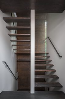 The flat grain of the windows' wooden frames make them appear as it they were carved from the façade.