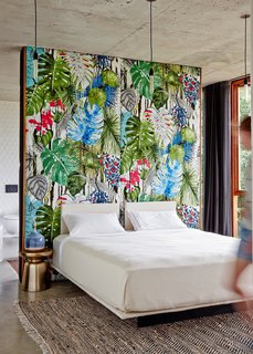  The wall in the master bedroom is upholstered in tropical print fabric by Christian Lacroix. 